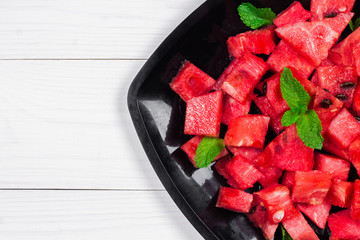 Slices of watermelon on a plate on a wooden background
