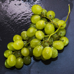 Bunch of grapes on a black slate stone