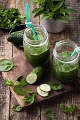 Fresh green smoothie with straws on a wooden table,healthy vegan food