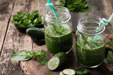 Fresh green smoothie with straws on a wooden table,healthy vegan food