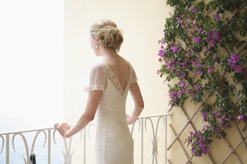 A Woman In A White Dress Looking Out Over A Balcony; London, England