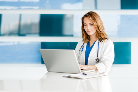 Attractive Young Woman Doctor Nurse Practitioner Physician Assistant In Hospital Clinic Medical Office With Laptop Computer