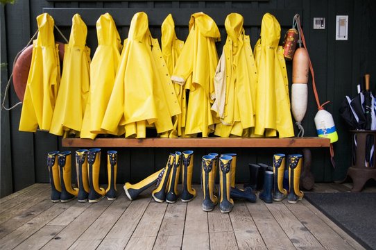 Yellow Raincoats And Rubber Boots Lined Up; Tofino, British Columbia, Canada