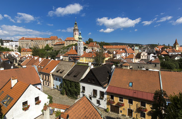 Fototapeta na wymiar Panoramic view of Czech city Cesky Krumlov. European tile roof houses, a river and a bridge over it full of people in South Bohemian Region.