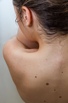 Blonde girl bathing in a bathtub full of milk and water. Pictured is a part of your body. The photo is from behind, her back and her neck looks. 