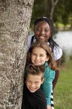 Fort Lauderdale, Florida, United States Of America; Three Preteens Beside A Tree In The Park