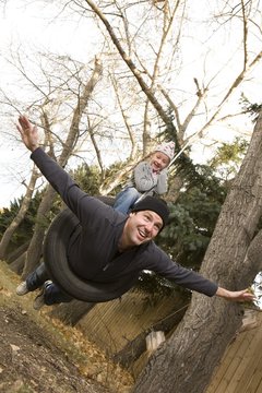Father And Daughter On Tire Swing