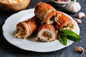 Pork cutlets wrapped in bacon and stuffed with cheese, spinach and sun dried tomato