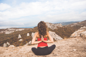 Girl doing meditation in mountains landscape