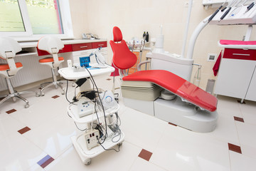 Stand with instruments for dentistry photopolymer lamp, diatermokoagulyator, fiziodispenser and other equipment against the background of the dental unit and the chair. Modern dental office.
