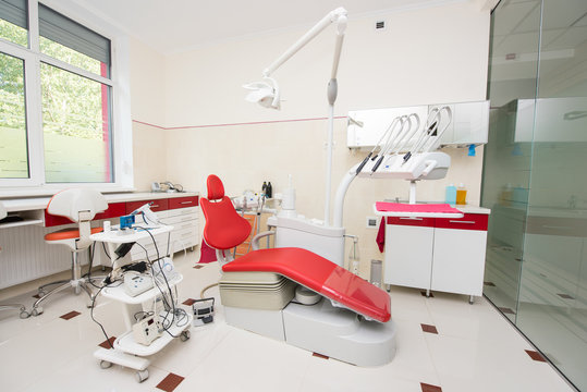 Modern dental clinic. Equipment for dentistry, dental unit and red chair