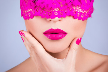 Woman with a pink blindfold on her face
