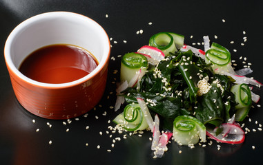 Obraz na płótnie Canvas Wakame salad on black plate
