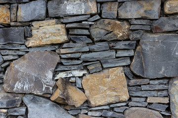 Fragment of the wall made of stones of different types and shape