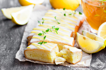 Lemonloaf  cake sliced on baking paper with green herb tea