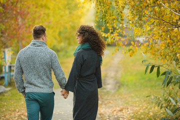 beautiful couple in the autumn forest. Curly girl