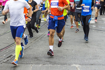 Marathon runners race in city streets, blurred motion