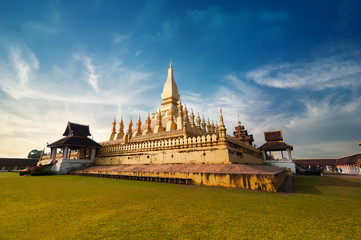 Religious architecture and landmarks. Golden buddhist pagoda of Phra That Luang Temple under sunset sky. Vientiane, Laos travel landscape and destinations