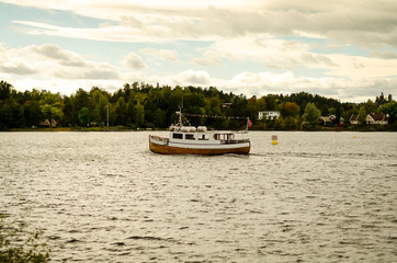 Fototapeta na wymiar wooden boat floating on norwegian fjord