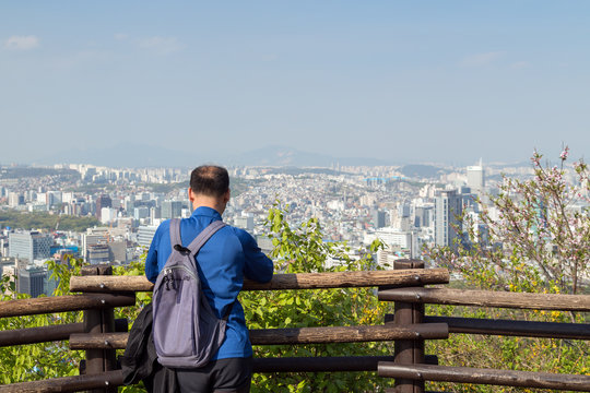 Man at an observation point watching the view of Seoul in South Korea. Copy space.