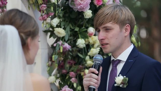 Newly married couple standind near wedding arch