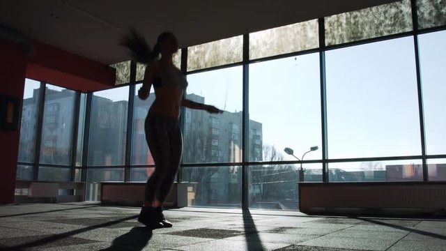 Young woman jump on skipping rope in gym