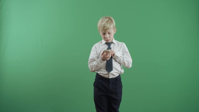 Serious little boy talking on phone