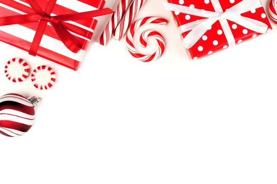 Christmas Corner Border Of Red And White Gifts And Peppermint Candies Over A White Background