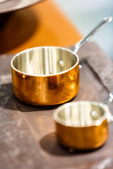 Copper cookware, pots and pans are on the counter in the store.