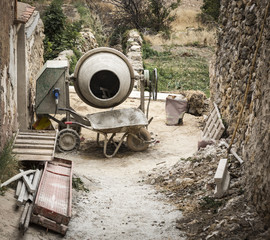 construction tools - an electric cement Mixer a wheelbarrow and scaffoldings