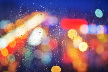 Obraz na płótnie Canvas rain drops on glass window viewing city lights on a dark weather