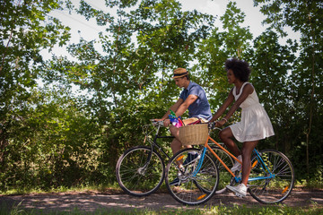 Plakat Young multiethnic couple having a bike ride in nature