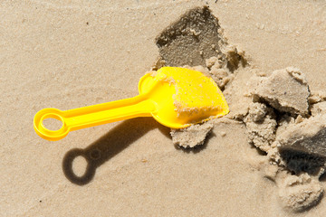 Fototapeta na wymiar Spade digs wet sand.