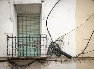 a balcony and a mess of electrical wires outside of a building