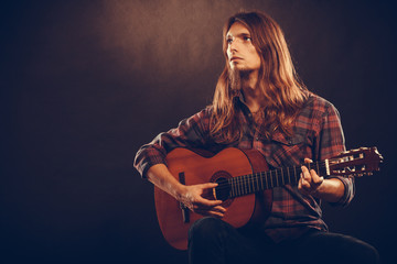 Young musican practicing with guitar.