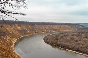 Natural autumn landscape with sandy slopes and the river