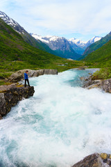 Tourist woman by Videfossen Waterfall in Norway