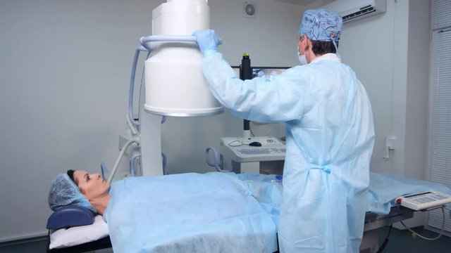 Interventional radiologist performs endovascular surgery operation with angiography machine,  uterine fibroid embolization