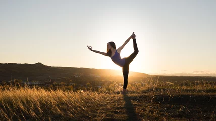 Foto op Aluminium Woman doing yoga dancers pose during sunset © tslphoto