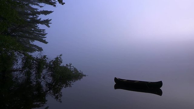 Wide Shot Of Empty Canoe In Foggy Lake