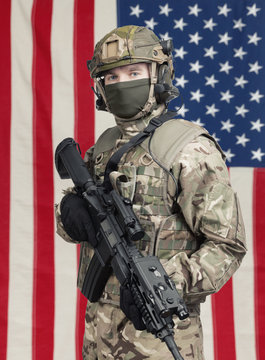 USA soldier with machine gun in hand and American flag on background