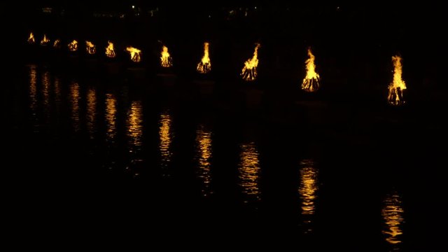 Slow motion of torches burning besides water
