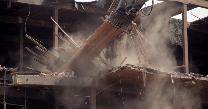Wide shot of crane demolishing building
