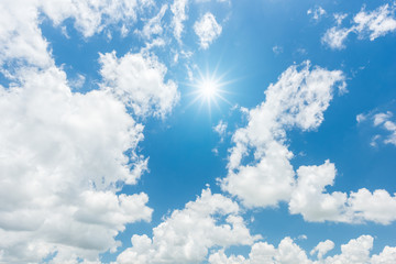 Blue sky with clouds and sun reflection. looking up view