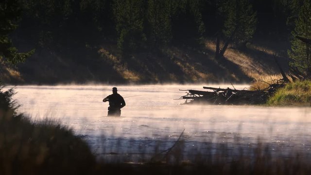Fisherman fly fishing in water at Yellowstone National Park