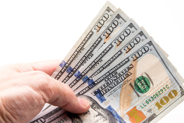 Five One hundred dollar bills being held in hand.