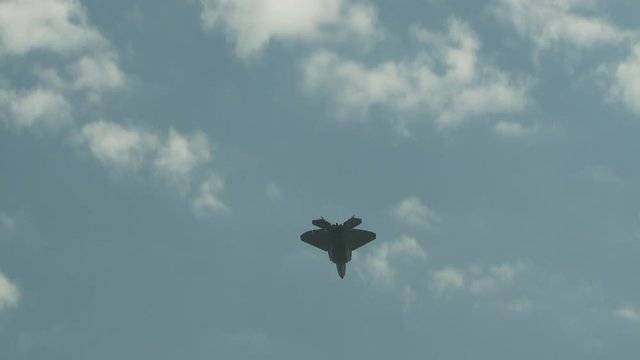 Zoom in shot of F22 fighter jet flying in sky