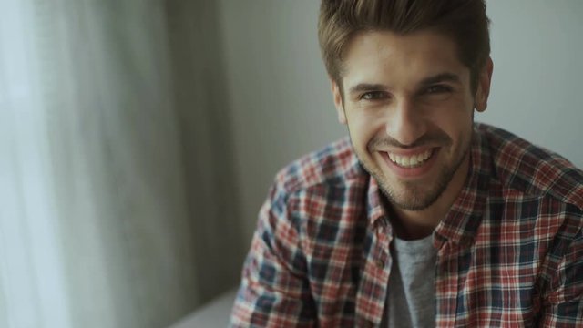 Happy young man. Portrait of handsome young man in casual shirt keeping arms crossed and smiling