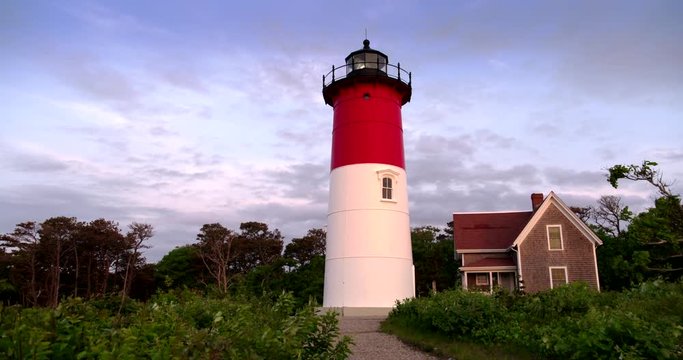 Wide shot of Nauset Lighthouse and house against cloudy sky
