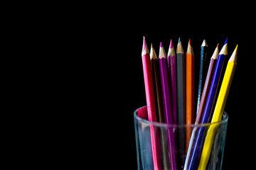 Fototapeta premium Color pencil on black background with copy space